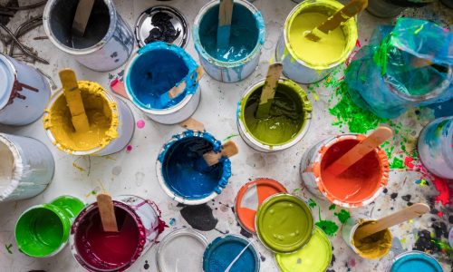 Overhead view of stirrers in paint pots in surfboard maker's workshop